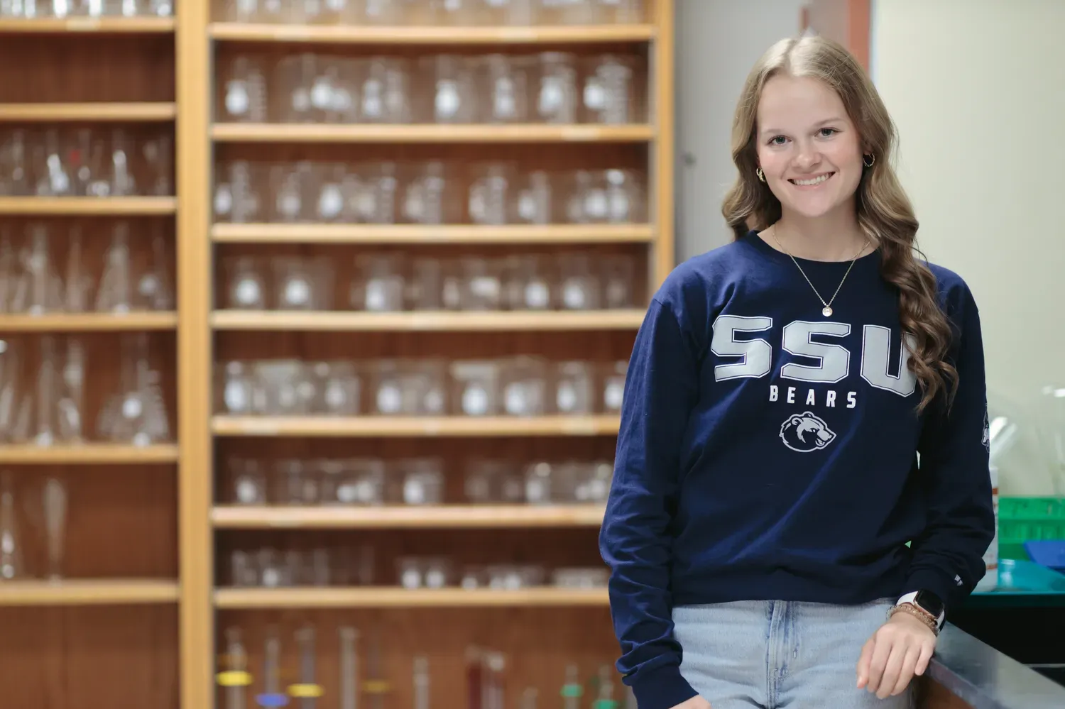 Student in a lab with glass beakers