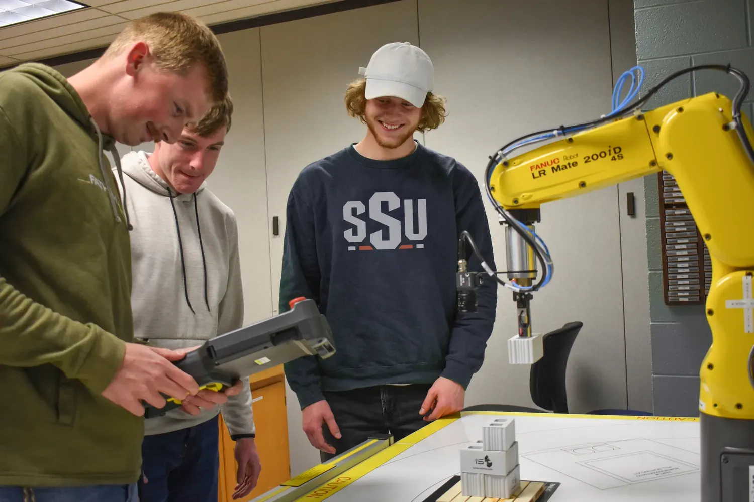 Students demonstrating robotic arm