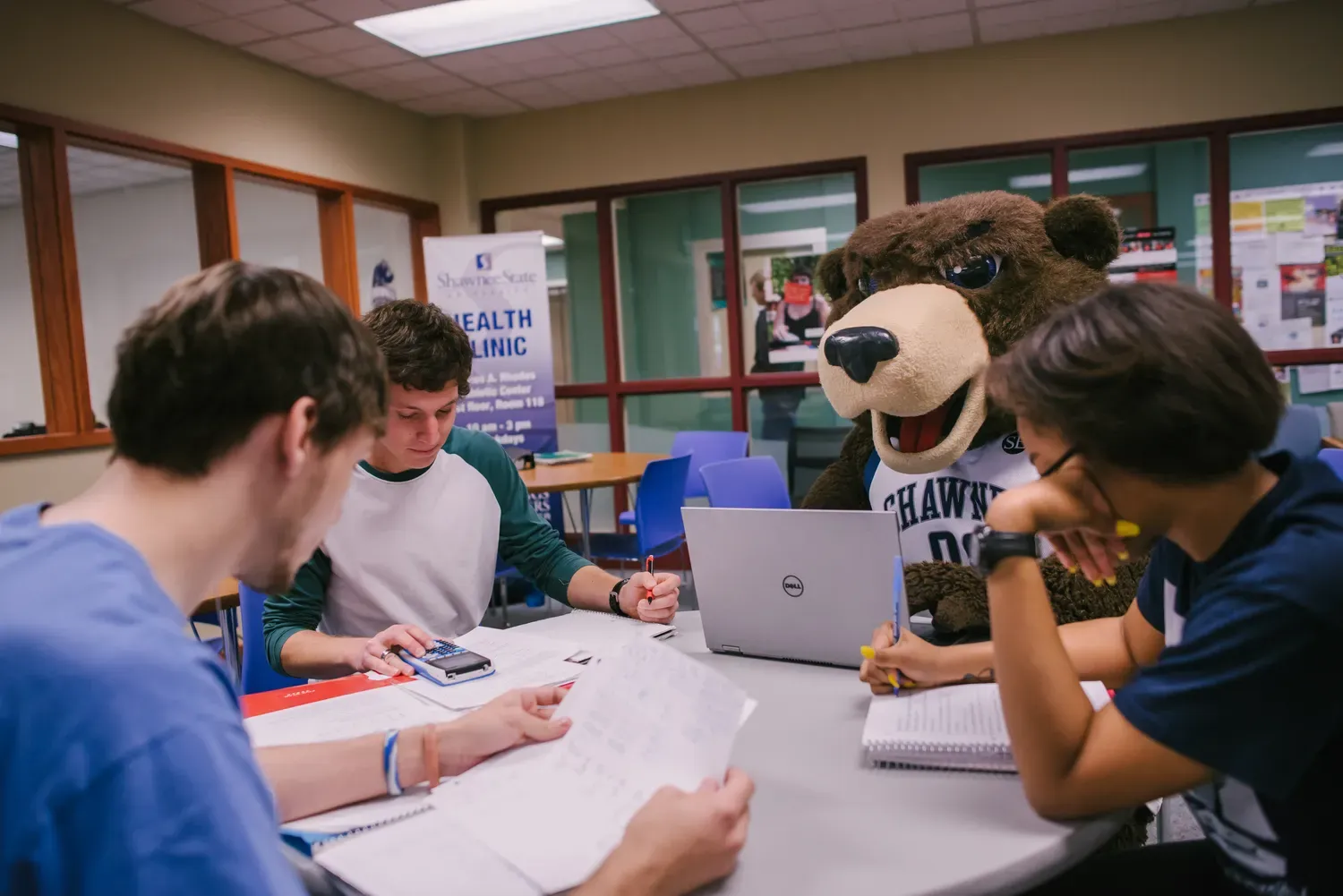 3 students sitting with Shawne E Bear Studying