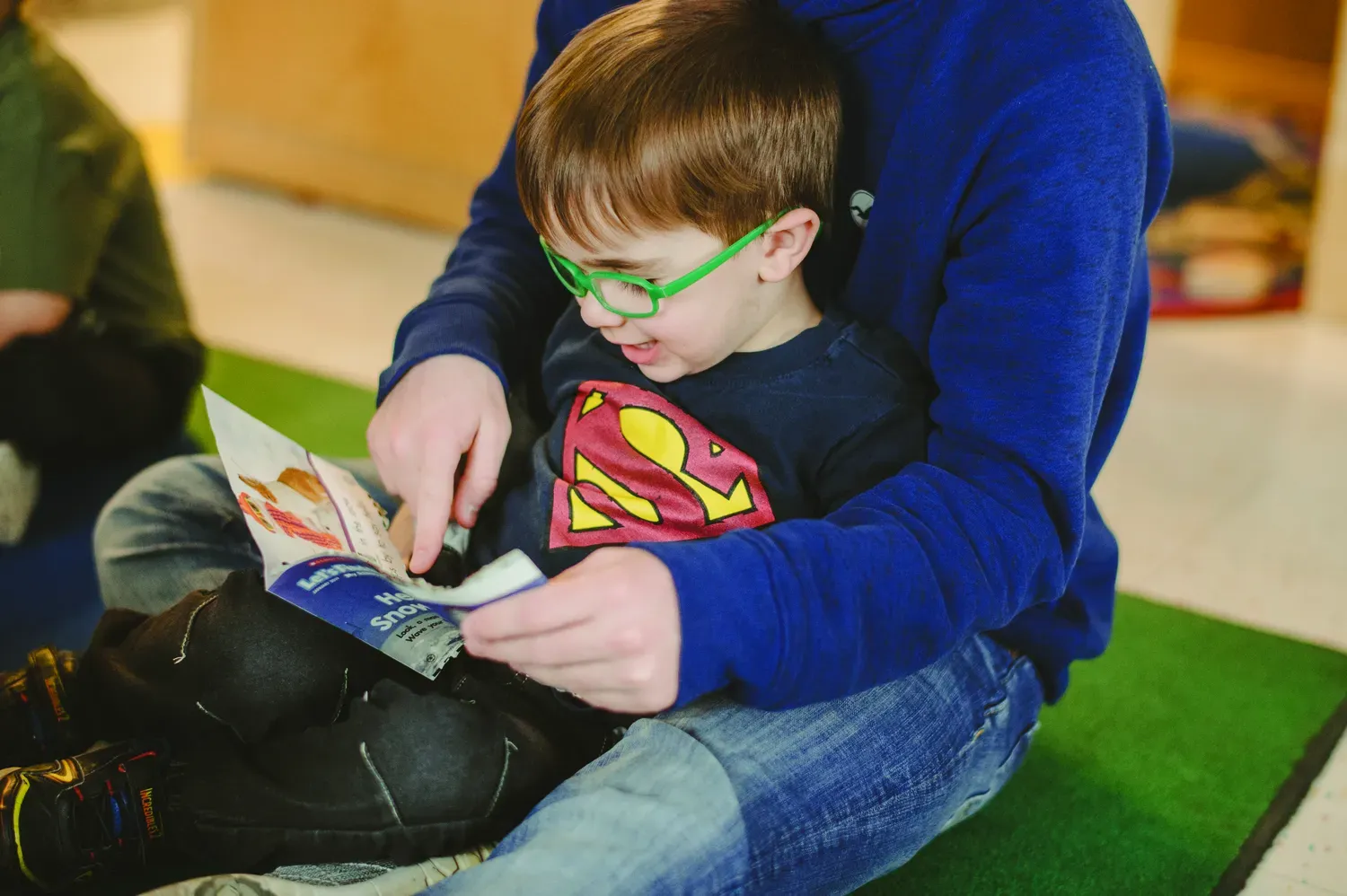 Student sitting with teacher reading