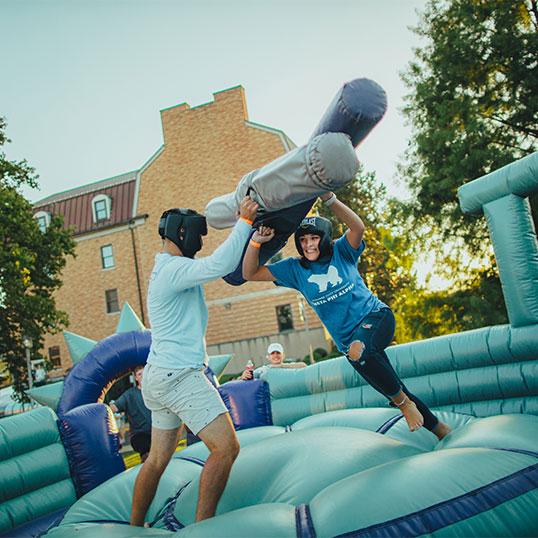 Students playing on bounce house 