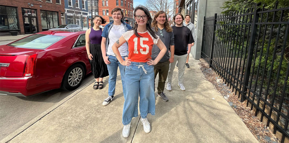 Group of students standing with Riley Galloway on a sidewalk